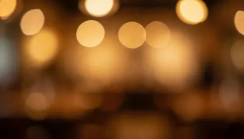 Fond de lumières chaudes et floues dans un bar, idéal pour ajouter du texte et du design graphique.