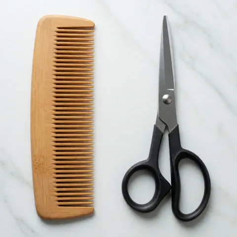 Peigne en bois et ciseaux de barbier posés sur une surface en marbre blanc, offrant une image propre et professionnelle adaptée à un usage commercial.