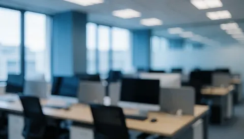 Espace de travail corporatif moderne avec bureaux, ordinateurs et fenêtres, aux tons bleus et gris, idéal pour la comptabilité et les finances.