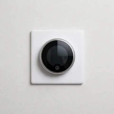Thermostat digital moderne monté sur un mur, affichant un design minimaliste et épuré, adapté aux intérieurs contemporains.