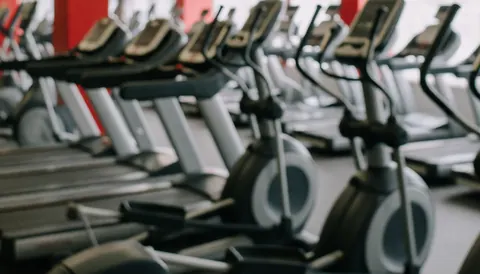 Arrière-plan de salle de sport avec des équipements de fitness flous et un espace réservé pour le texte, idéal pour les promotions et les annonces.