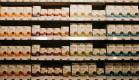Arrière-plan flou d'étagères remplies de produits de nutrition avec des tons chauds, offrant un espace idéal pour ajouter du texte commercial.