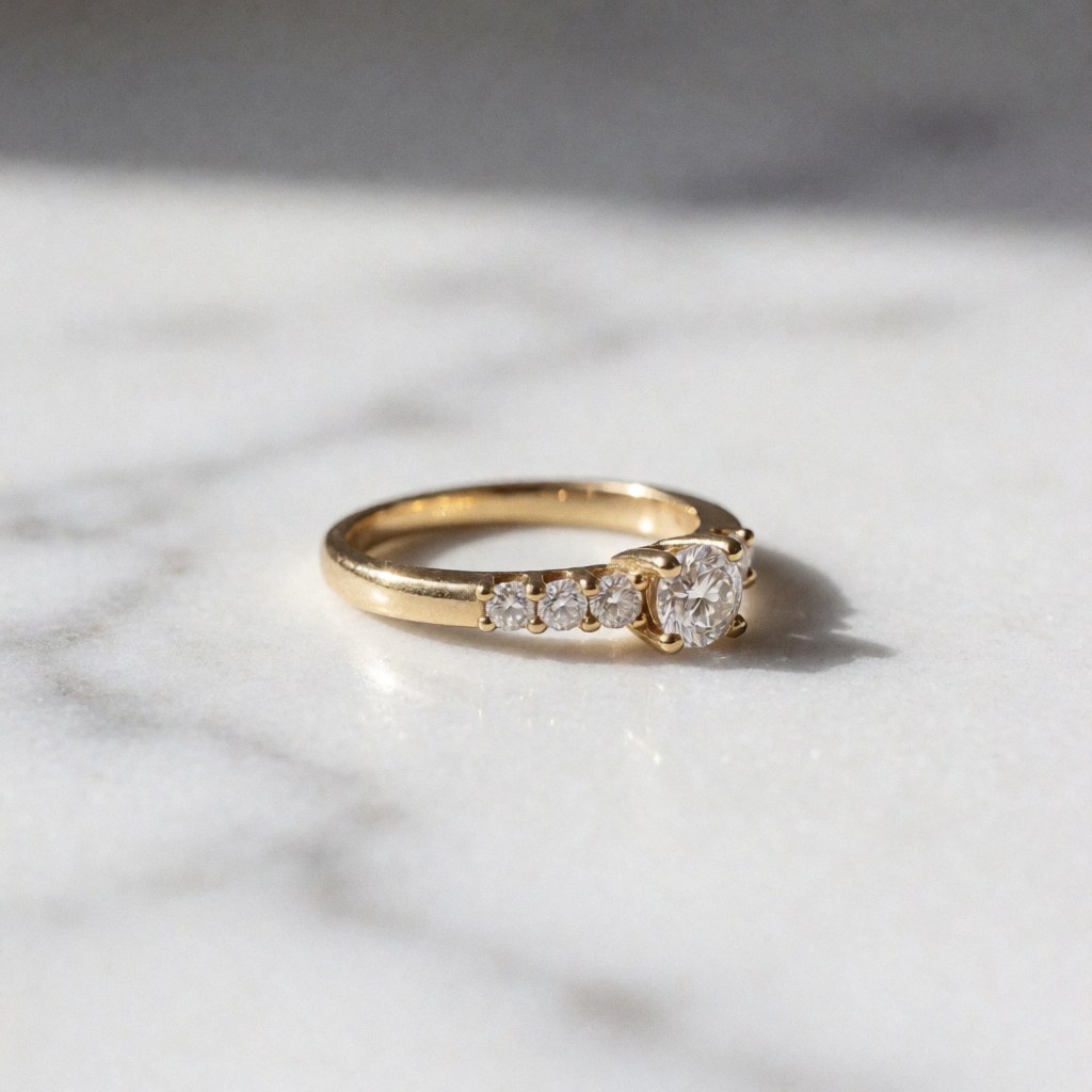 Une bague en or ornée de diamants brillants posée sur une surface en marbre, éclairée par une lumière latérale douce qui accentue l'éclat des pierres précieuses.