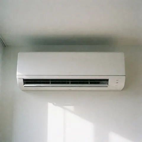 Climatiseur mural blanc installé en intérieur avec éclairage naturel et ombres douces, adapté aux environnements commerciaux.
