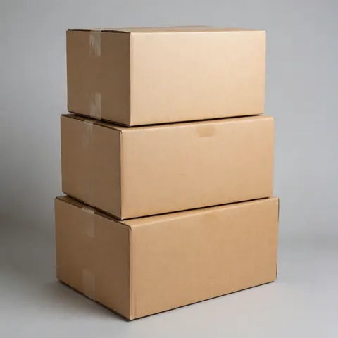 Trois cartons empilés et attachés avec du ruban adhésif sur un fond gris neutre, idéal pour la logistique et le transport.