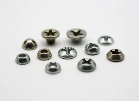 Détail macro de plusieurs vis en métal avec tête cruciforme posées sur un fond blanc uni, adapté aux magasins de quincaillerie et aux projets de bricolage.