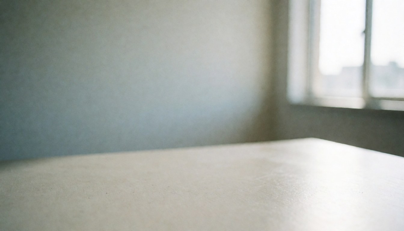 Un bureau blanc lisse dans un bureau avec un mur et une fenêtre en arrière-plan, idéal pour les présentations ou le travail.