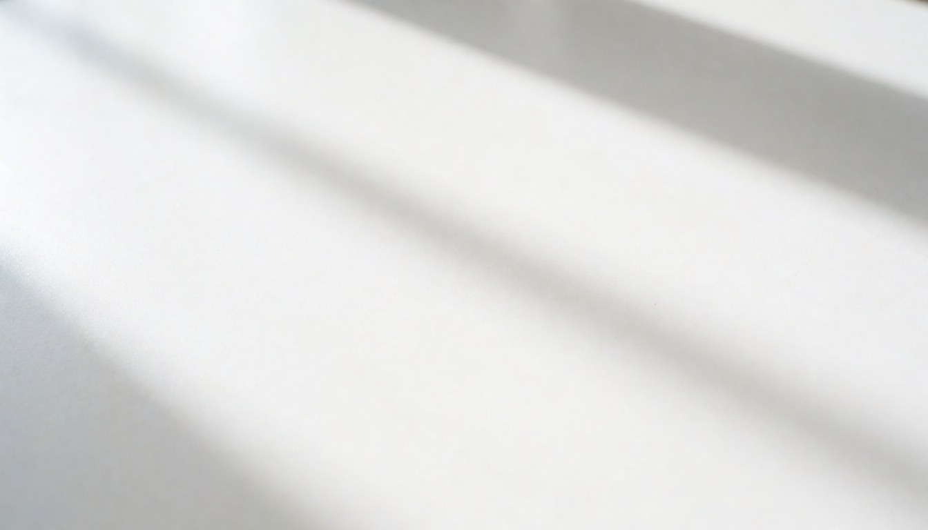 Surface blanche lisse avec des ombres douces de lumière naturelle, idéale pour créer des arrière-plans minimalistes et épurés.