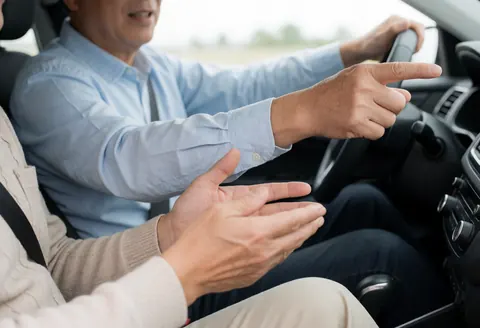 Un instructeur donne des instructions à un étudiant pendant qu'il conduit une voiture.