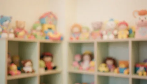 Étagères floues avec des figurines et des jouets pastel, offrant une ambiance chaleureuse et sécurisante, idéale comme arrière-plan pour du texte.