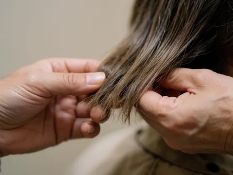 Gros plan sur des détails de cheveux sains brillants et soignés mettant en valeur la texture et le soin capillaire.
