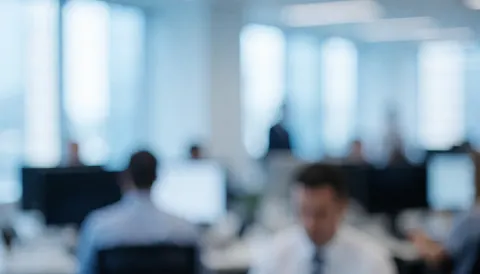 Vue d'un environnement de travail moderne avec des éléments de bureau indistincts, créant un fond neutre et professionnel adapté à la mise en page.