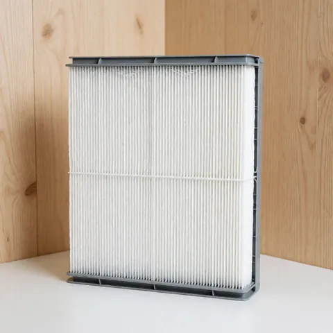 Vue de face d'un nouveau filtre à air rectangulaire blanc avec bordure grise, propre et prêt pour l'installation dans un système de ventilation domestique.