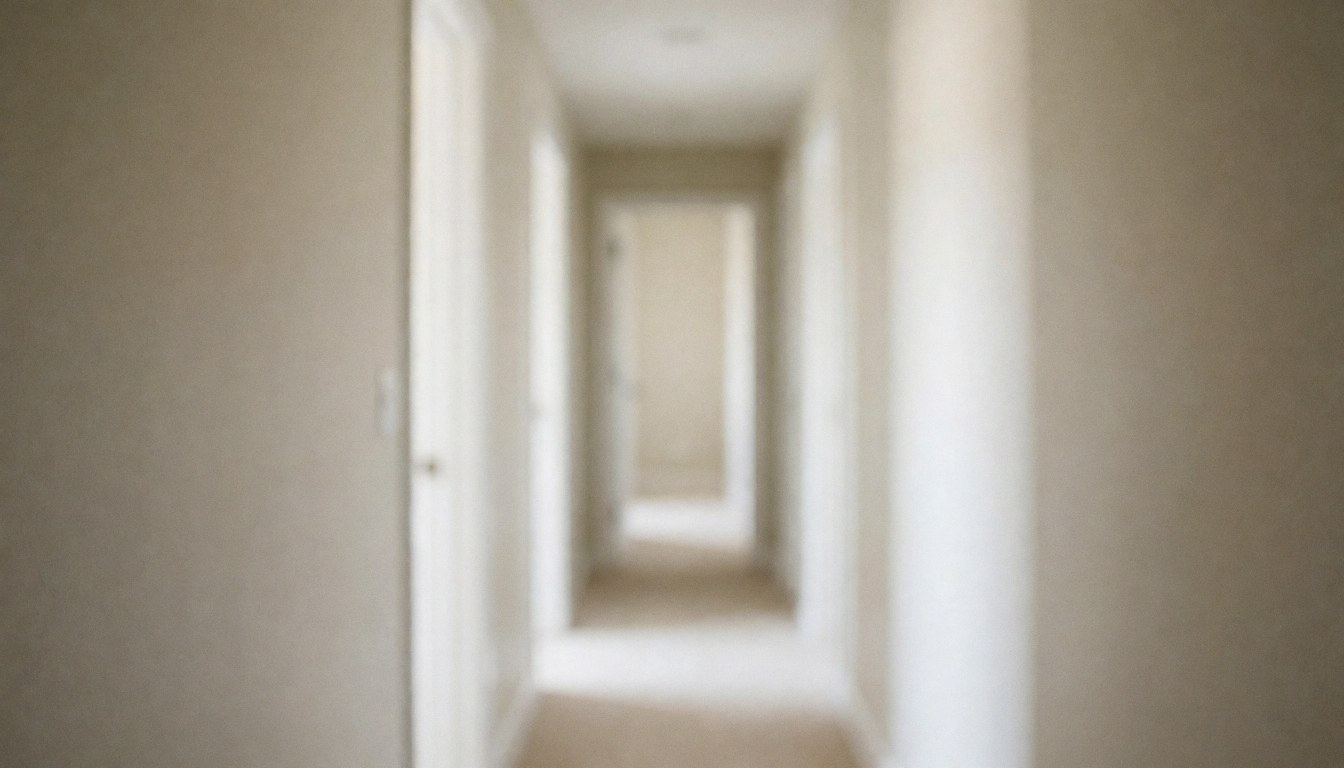 Vue d'un couloir intérieur épuré aux murs blancs et à une porte beige, servant de fond neutre pour textes ou présentations professionnelles.