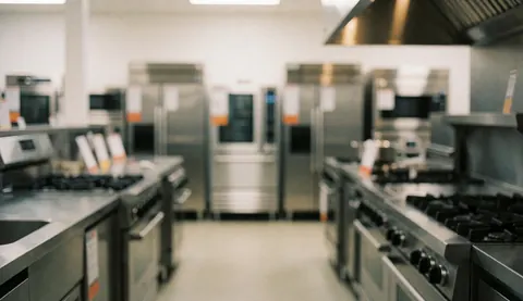 Arrière-plan épuré mettant en valeur du matériel de cuisine industrielle en acier inoxydable, idéal pour ajouter du texte ou des informations commerciales.