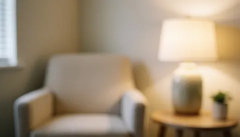 Coin douillet d'un cabinet de psychologie comprenant une chaise blanche, une lampe et une plante, idéal pour des textes sur le soutien émotionnel et les services de thérapie.