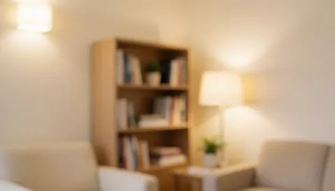 Intérieur d'un cabinet de psychologie avec murs beiges, étagère et lumière chaleureuse, idéal pour ajouter du texte.