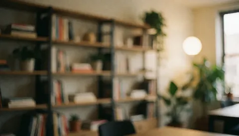 Arrière-plan de bureau moderne avec étagères remplies de livres, plantes vertes et lumière chaleureuse, idéal pour textes et présentations professionnelles.
