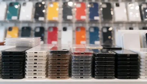 Étagères remplies d'étuis et protections de smartphones aux couleurs vives, servant de fond commercial pour textes et promotions.