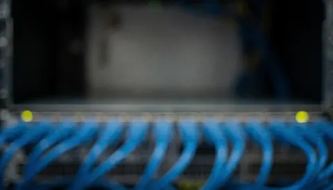 Arrière-plan abstrait de serveurs avec des câbles bleus et des lumières, idéal pour le texte sur les logiciels et les startups, ambiance professionnelle et technologique.