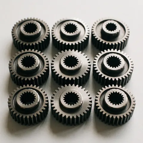 Vue rapprochée d'engrenages métalliques mécaniques de haute précision sur un fond blanc propre pour l'industrie manufacturière.