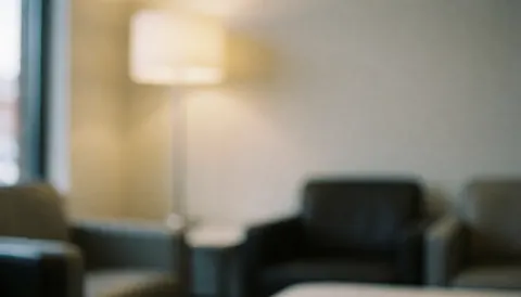 Arrière-plan flou d'un intérieur moderne avec des chaises et une lampe émettant une lumière chaleureuse, idéal pour superposer du texte.
