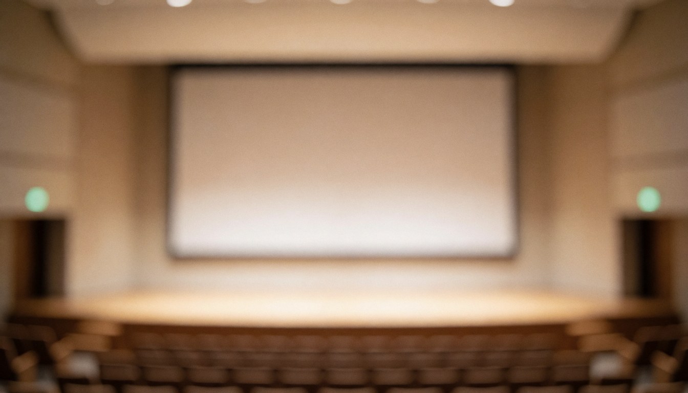 Arrière-plan flou d'un auditorium professionnel avec grand écran et sièges, idéal pour textes et présentations corporatives.
