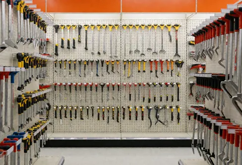 Vue d'un couloir bien rangé dans une quincaillerie avec des outils suspendus au mur.