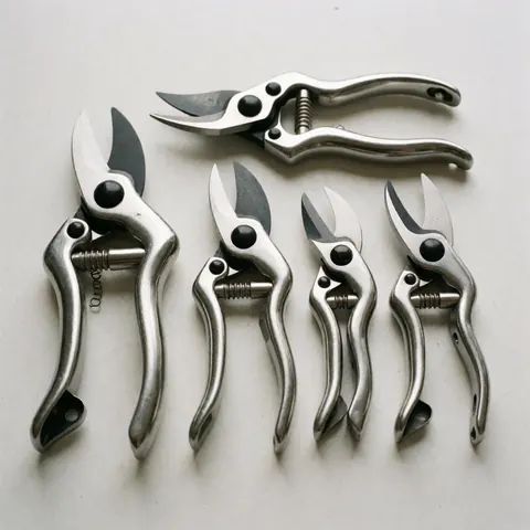 Des outils de jardinage professionnels en acier inoxydable disposés sur une surface en ardoise pour la vente commerciale.