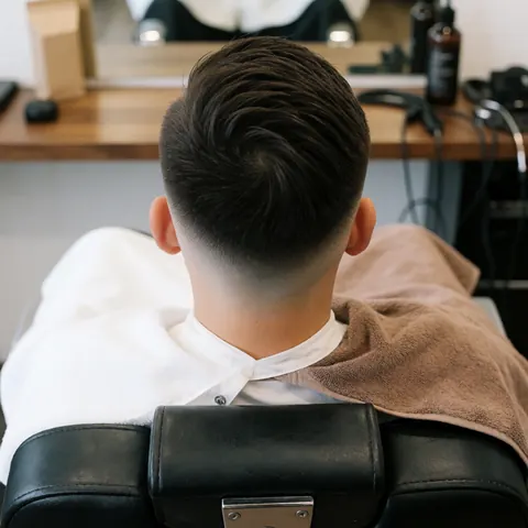 Photo montrant le résultat final d'une coupe de cheveux moderne pour homme, mettant en valeur la précision du travail.