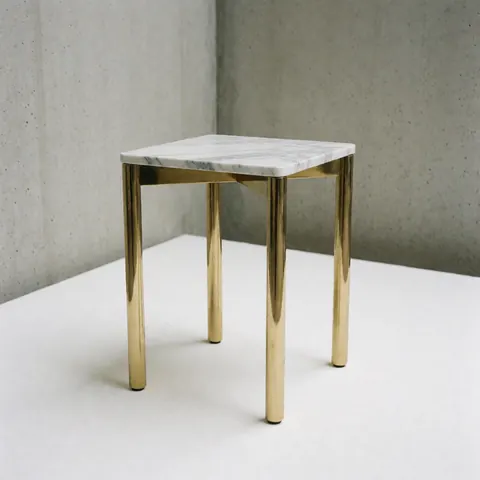 Vue de face d'une table d'appoint moderne en marbre blanc avec des pieds métalliques dorés, idéale pour un intérieur contemporain et élégant.