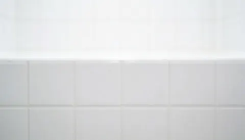 Surface plane composée de carreaux de céramique blancs disposés en grille, servant de fond neutre et propre pour du texte ou des publicités.