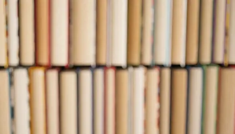 Vue d'arrière-plan texturée mettant en scène une accumulation de livres aux couvertures variées, créant un fond visuel riche et détaillé pour un usage professionnel.