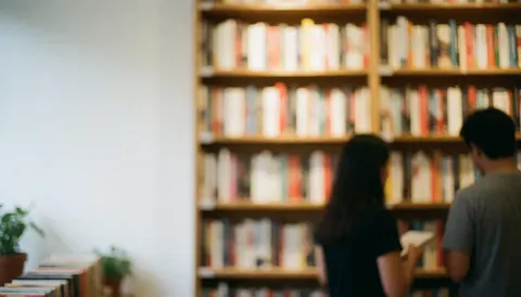 Vue floue de l'intérieur d'une librairie avec des étagères en bois remplies de livres, créant un arrière-plan calme et élégant pour du texte.