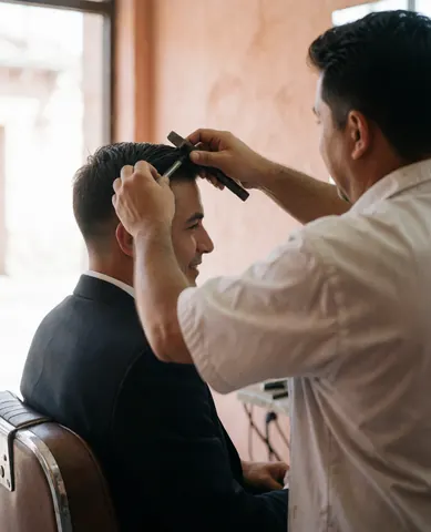 Un client satisfait après sa coupe chez le barbier.