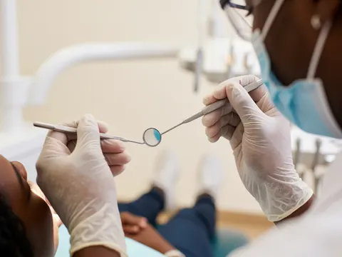 Gros plan sur un instrument dentaire métallique utilisé lors d'une consultation en clinique odontologique.