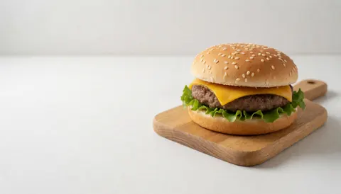 Un hamburger appétissant posé sur une planche en bois, offrant un espace vide sur fond blanc pour ajouter du texte ou des informations promotionnelles.