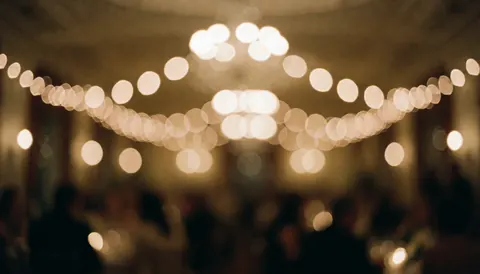 Un fond lumineux avec un effet bokeh chaleureux et flou, idéal comme arrière-plan texturé pour des invitations de mariage ou des événements festifs.