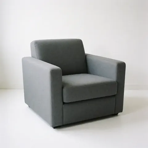 Un fauteuil gris moderne est photographié seul sur un fond blanc uni, mettant en valeur son design épuré et sa forme confortable pour un usage commercial.
