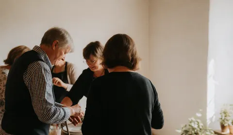 Scène de préparation d'un événement dans une ferme avec tables, décorations et équipe au travail.