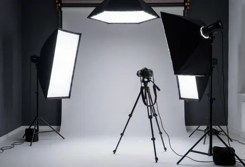 Vue d'un studio photographique professionnel équipé de softbox, trépied et fond gris pour des prises de vue commerciales.