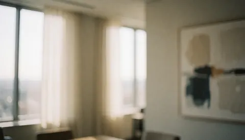 Bureau moderne avec fenêtres, rideaux et art abstrait sur le mur, fond doux et neutre pour textes de services financiers.