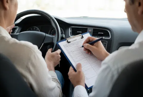 Intérieur d'un véhicule pendant un examen de conduite, montrant l'examinateur tenant des formulaires et le conducteur prêt à passer l'épreuve.