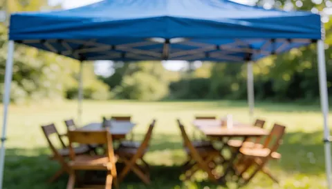 Toit bleu avec tables et chaises en bois sur un champ vert, lumière naturelle, fond flou, idéal pour textes et présentations.