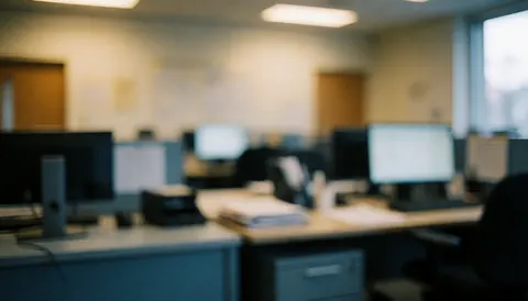 Arrière-plan flou d'un bureau avec des tons gris et blanc, idéal pour ajouter du texte dans un contexte professionnel.