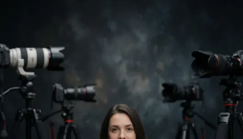 Équipement photographique professionnel composé de plusieurs appareils photo montés sur des trépieds, disposés devant un arrière-plan sombre et texturé.