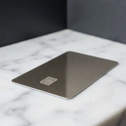 Gros plan sur une carte de crédit en métal avec un motif marbré blanc et gris évoquant la modernité et le design minimaliste.