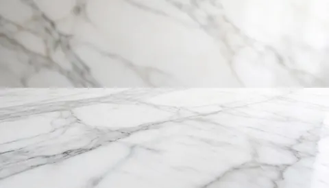 Surface de marbre blanc avec des veines grises foncées, offrant une texture élégante et luxueuse, idéale comme arrière-plan pour du texte dans un contexte architectural ou intérieur.