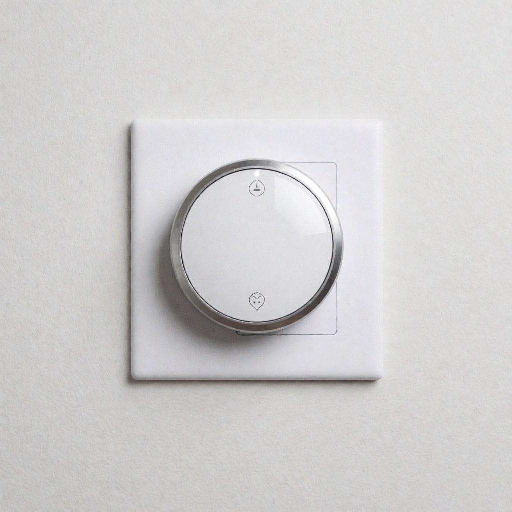 Un thermostat connecté avec écran numérique et boutons métalliques est fixé sur un mur blanc dans une salle de bain au design minimaliste et épuré.