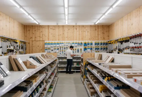 Vue intérieure d'un magasin de fournitures pour l'entrepreneur avec des outils et du bois en rayon.